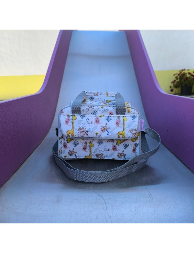 Lancheira com animais da selva, tais como: girafas, macacos e passarinhos. Alças, contorno e fecho em cinzento