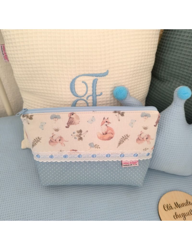 Necessaire azul claro com pintinhas brancas conjugado com um padrão de animais da floresta. Com bordado inglês e fita de cetim azul