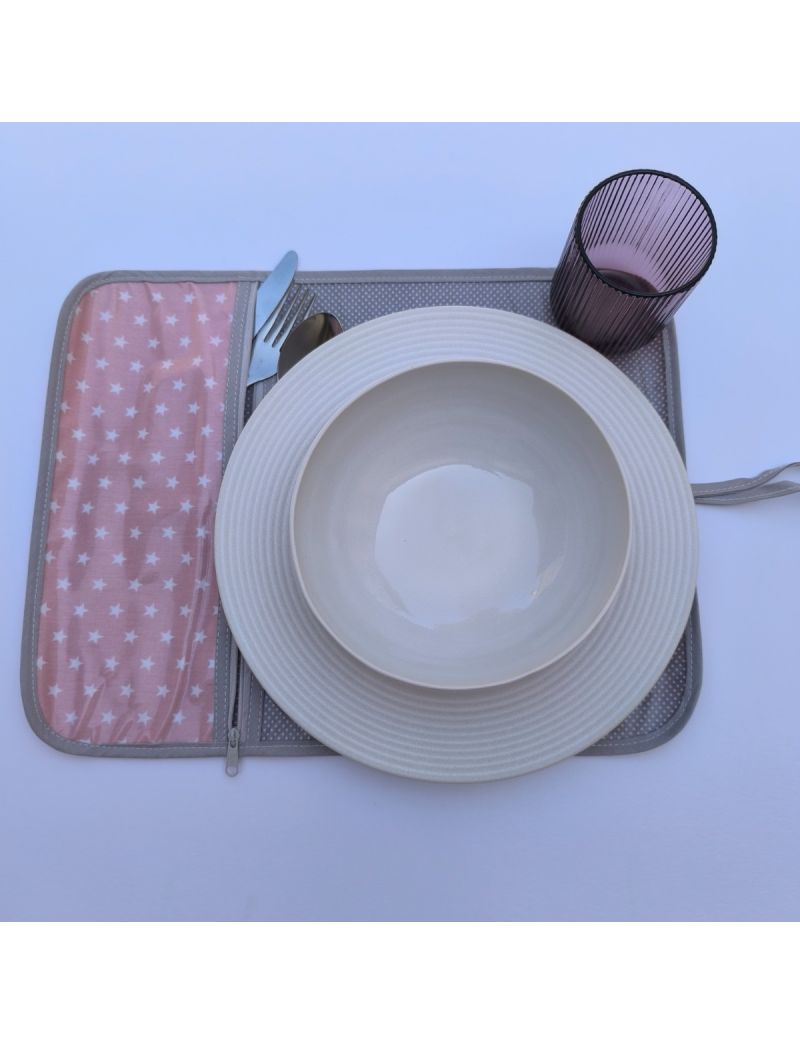 Individual cor-de-rosa com estrelas brancas no exterior e cinzento com pintinhas brancas no interior. Bolsa interior com padrão igual ao exterior