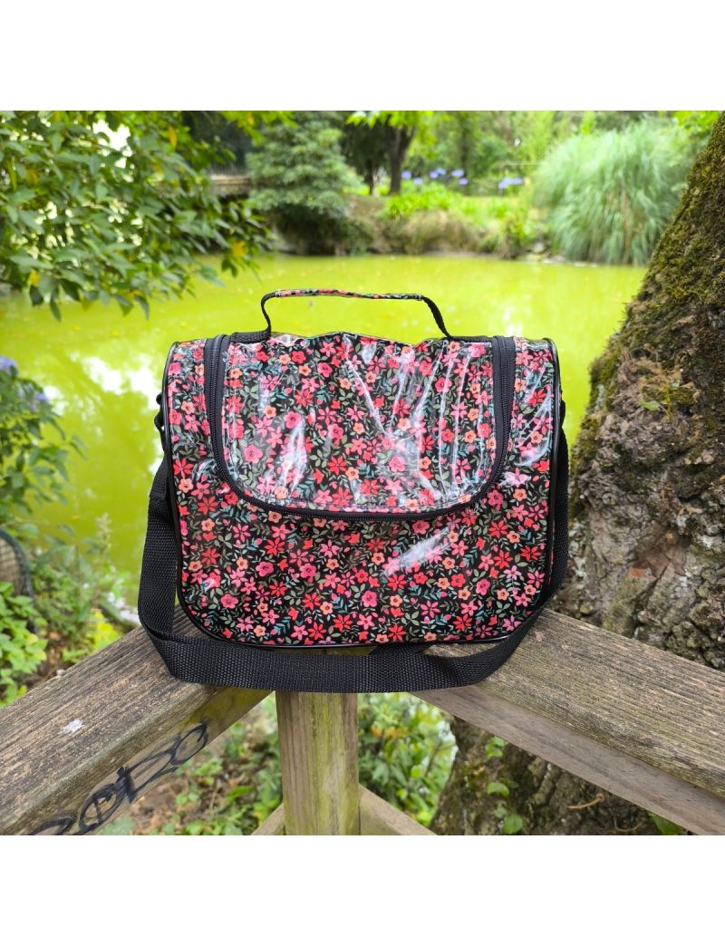 Lancheira térmica em tecido plastificado preto com flores em tons de vermelho e salmão. Alça e fecho em preto