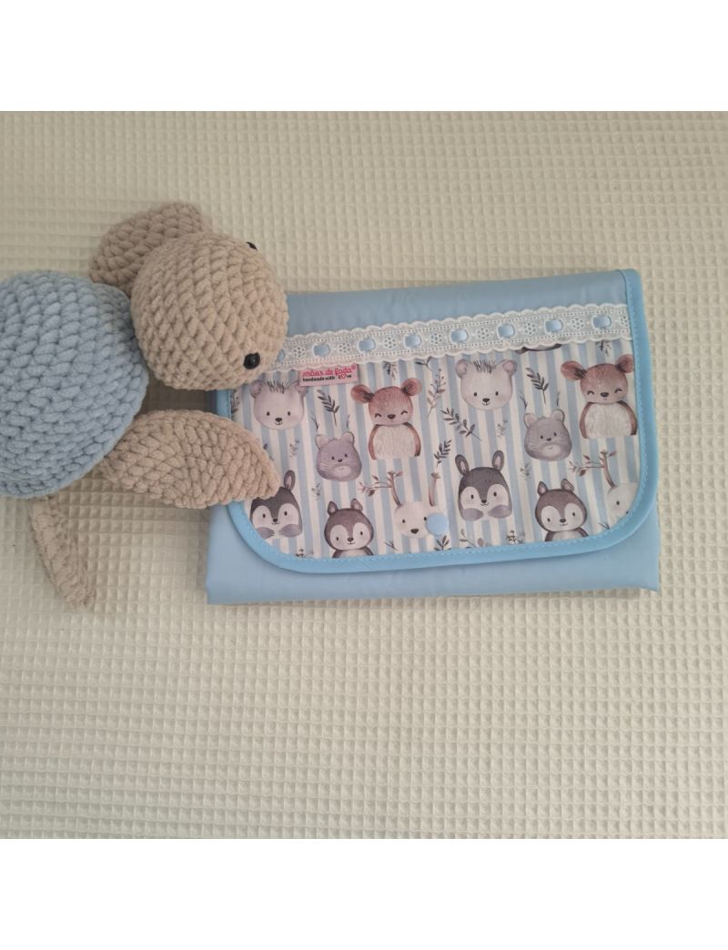 Muda fralda fechado com tecido azul claro conjugado com tecido de animais. Com bordado inglês com fita azul. Tartaruga em amigurumi a decorar 