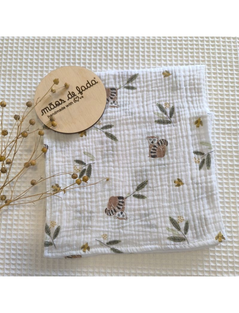 Fralda musselina fundo branco com folhagens e animais. Placa decorativa em madeira com a designação "Mãos de Fada"