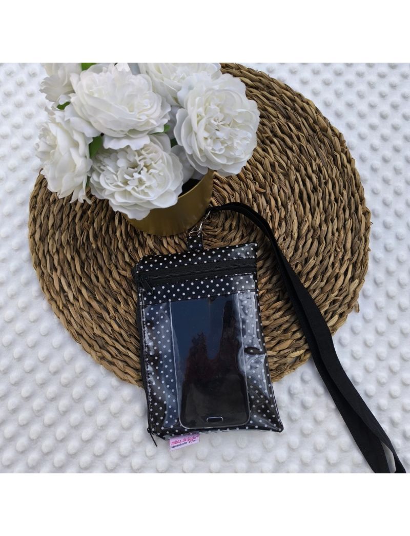 Parte da frente da Bolsa 3 em 1 preta com bolinhas brancas. Bolsa transparente com um telemóvel. Fita amovível para colocar ao pescoço. Base e flores como decoração 
