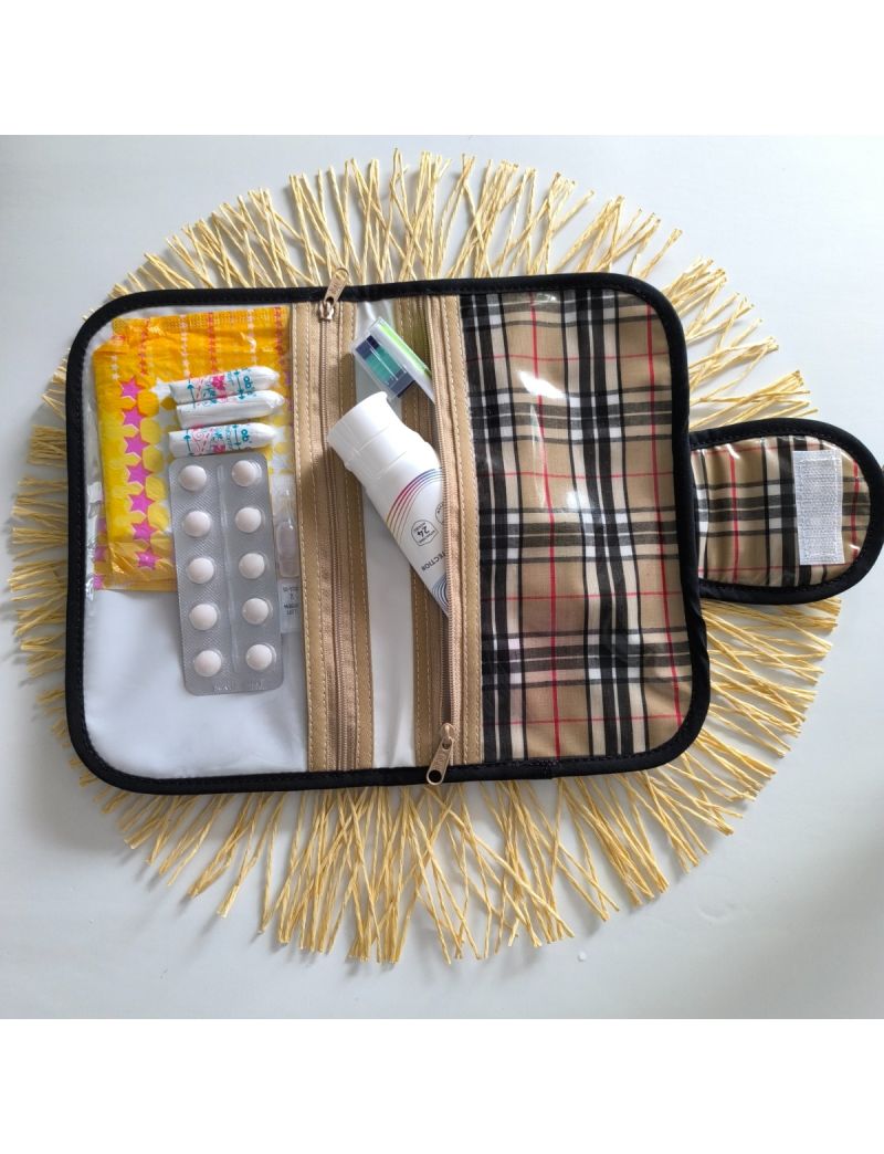 Bolsa de higiene plastificada com padrão xadrez bege e preto, aberta, com compartimentos para higiene oral, medicação e produtos femininos
