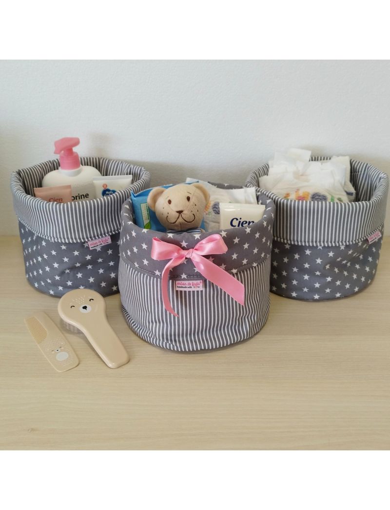 Conjunto de três cestos organizadores cheios com produtos essenciais para a higiene do bebé.Estrelas e riscas cinzentas  