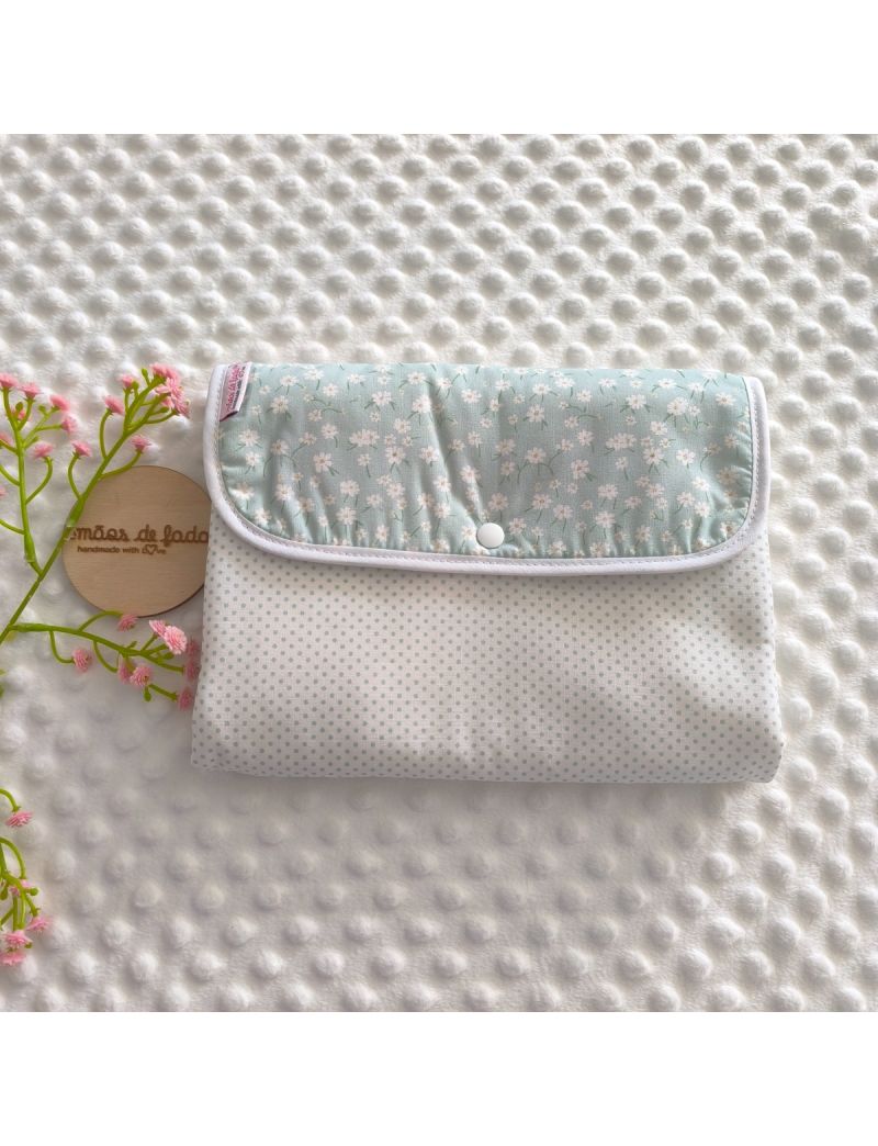 Bolsa 3 em 1 fechada para organizar fraldas, toalhitas, cremes e essenciais do beb&eacute; com um ador&aacute;vel padr&atilde;o de floral branco com fundo verde &aacute;gua, conjugado com um tecido branco com bolinhas verdes 