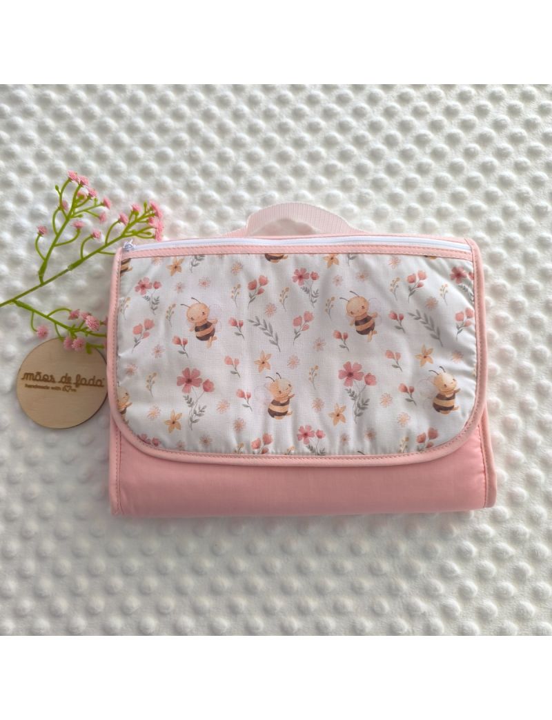 Bolsa Multiusos fechada com padr&atilde;o de abelhas e flores sobre fundo branco e rosa. Fecho z&iacute;per  branco