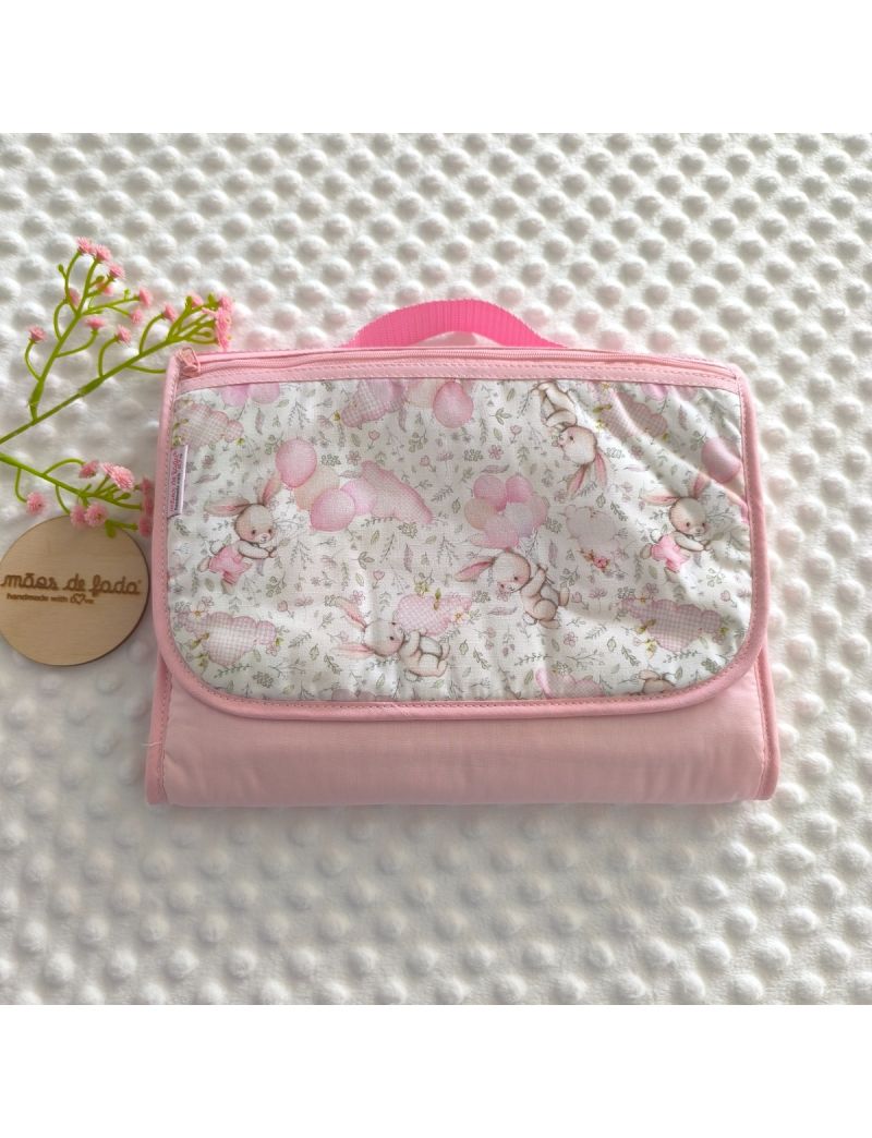 Bolsa multiusos para beb&eacute; em rosa com padr&atilde;o de coelhinhos e bal&otilde;es, fechada com pega de m&atilde;o