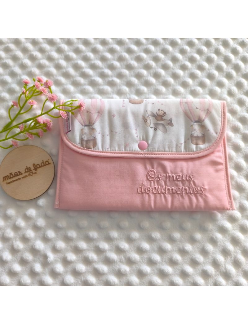 Porta documentos em formato envelope cor de rosa com pala com padr&atilde;o de bal&otilde;es de ar e avi&otilde;es em tons suaves 