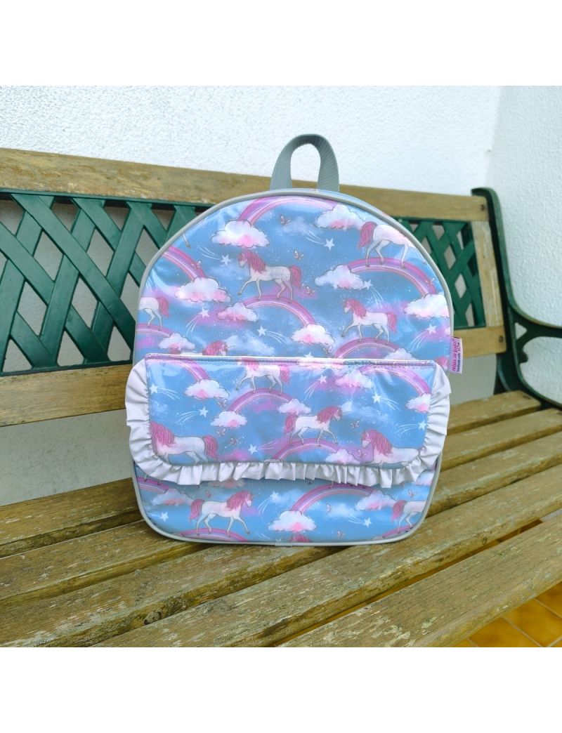 Mochila com padr&atilde;o de unic&oacute;rnios em azul acinzentado e tons de rosa Com pala &agrave; frente com um folho cinzento Fecho, contorno e la&ccedil;as em cinzento