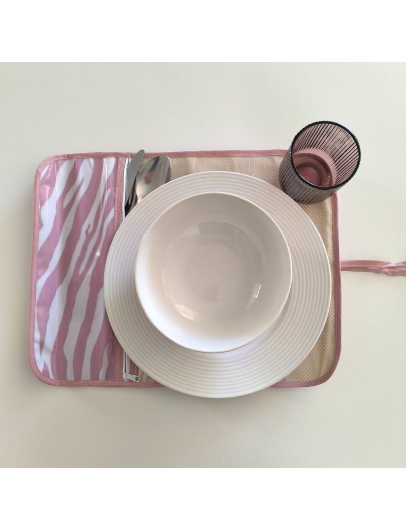 Individual aberto com de zebra branco e rosa velho na parte da bolsa para os talheres. Restante individual bege com bolinhas brancas.