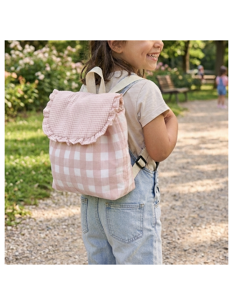 Menina com mochila colocada. Em tecido vicky rosa pastel m&eacute;dio e grande na pala, folho na pala. Com al&ccedil;as na cor p&eacute;rola