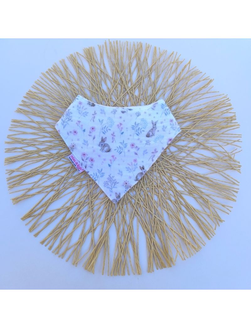 Babete infantil em formato badana ou len&ccedil;o triangular, feito em musselina de algod&atilde;o branca com o padr&atilde;o Bosque M&aacute;gico, composto por ilustra&ccedil;&otilde;es delicadas de pequenos coelhos e raminhos de flores silvestres em tons suaves de rosa e verde
