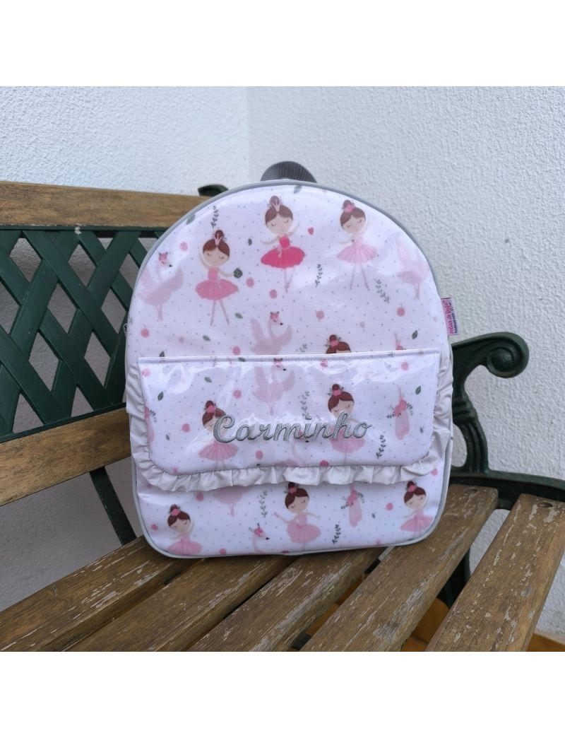 Mochila de criança com padrão de bailarinas. Pala com onome Carminho bordado a cinzento. Folho na pala cinzento
