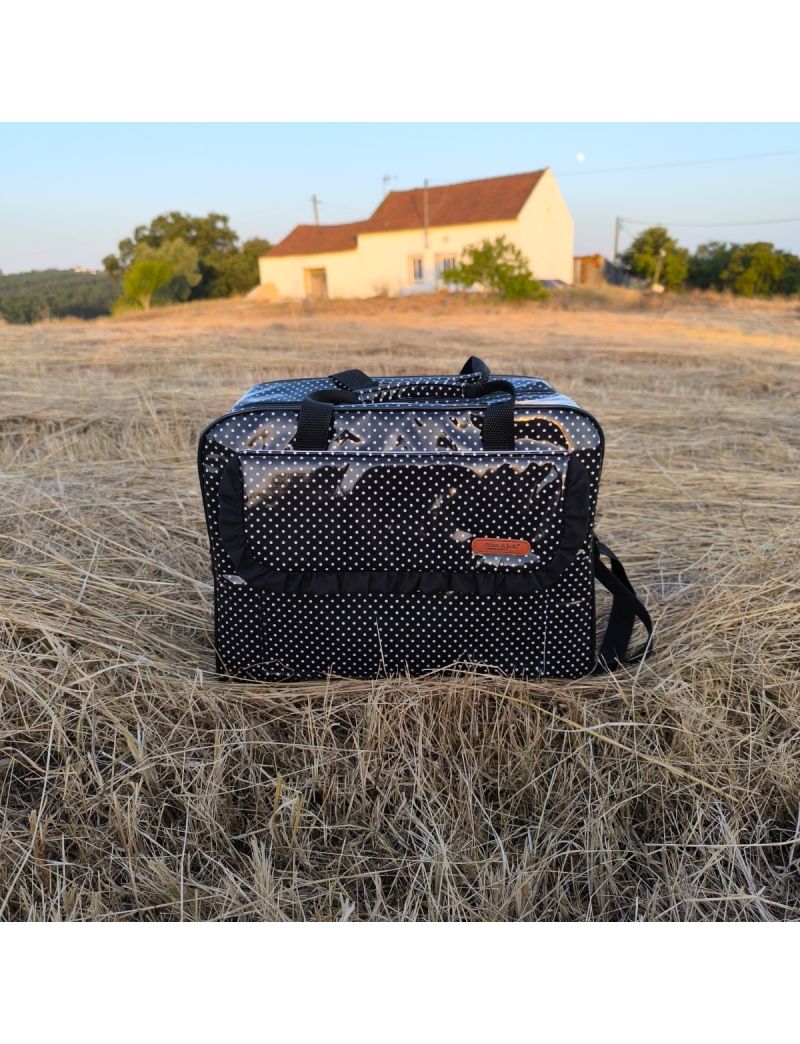 Lancheira térmica em tecido plastificado preto com bolinhas brancas. Com bolso frontal e pala com folho preto. Ideal para o trabalho ou escola