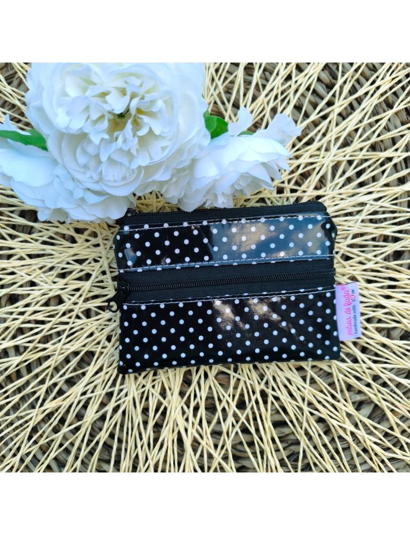 Porta-moedas pequeno em tecido plastificado impermeável, em preto com bolinhas brancas, com duas bolsas e fecho, ideal para dinheiro e cartões. 
