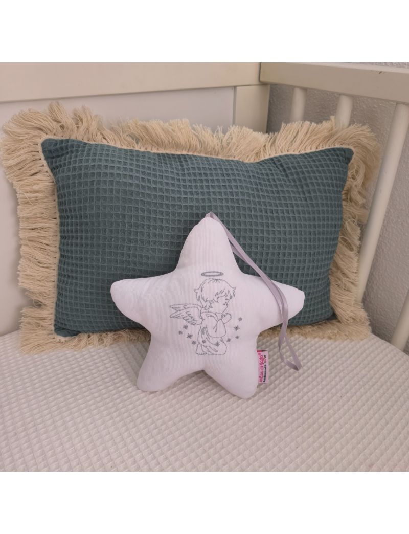 Estrela branca com anjo bordado a cinza, fita cinza e enchimento antialérgico, apoiada em almofadas decorativas num quarto de bebé