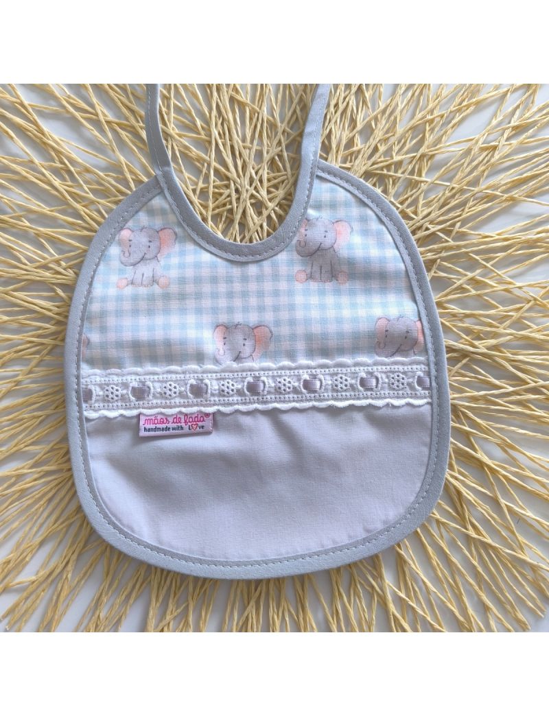 Babete com padrão de elefantes sobre um tecido quadriculado verde água, conjugado com tecido liso cinzento. Bordado inglês com fita de cetim cinzento 