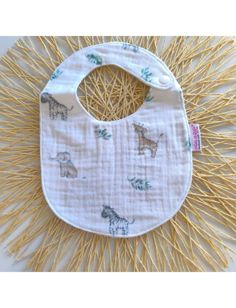 Babete de musselina branca com animais da floresta ilustrados, fecho de mola, ideal para bebés até aos 7 meses. 