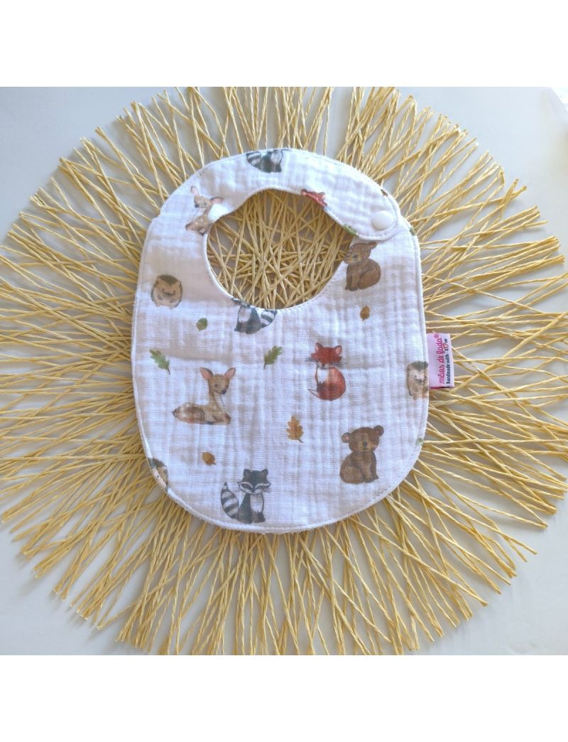 Babete de musselina branca com animais da floresta ilustrados, fecho de mola, impermeável, ideal para bebés até aos 7 meses. 