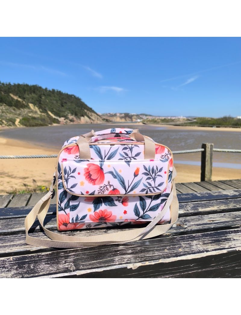 Lancheira t&eacute;rmica com padr&atilde;o floral delicado em tons de coral e folhagens verdes sobre fundo claro.  Possui uma bolsa frontal com pala, al&ccedil;as de m&atilde;o e al&ccedil;a a tiracolo regul&aacute;vel em bege suave, com acabamento em vivo bege.