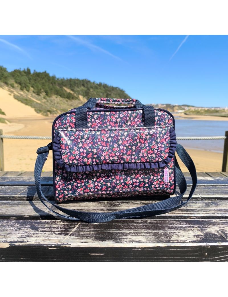 Lancheira t&eacute;rmica com padr&atilde;o floral denso em tons de azul-escuro. A lancheira apresenta uma bolsa frontal com pala e um detalhe de folho azul-marinho na borda inferior. As al&ccedil;as de m&atilde;o e a al&ccedil;a a tiracolo s&atilde;o azul-marinho.
