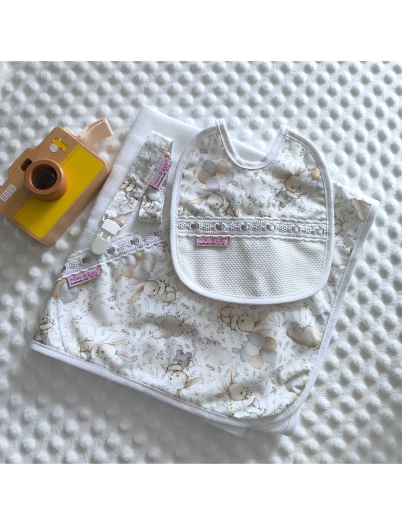 Conjunto de beb&eacute; composto por fralda branca com tri&acirc;ngulo de tecido com padr&atilde;o de coelhos e bal&otilde;es em tons delicados. Babete com o mesmo padr&atilde;o  conjugado com tecido p&eacute;rola liso e com bordado ingl&ecirc;s com fita de cetim cinzenta. Fita para a chucha com o mes