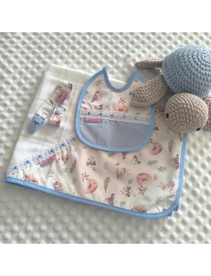 Conjunto de beb&eacute; com fralda, babete imperme&aacute;vel e fita de chucha com padr&atilde;o de animais da floresta (esquilos, raposas, coelhos) em tons de azul claro 