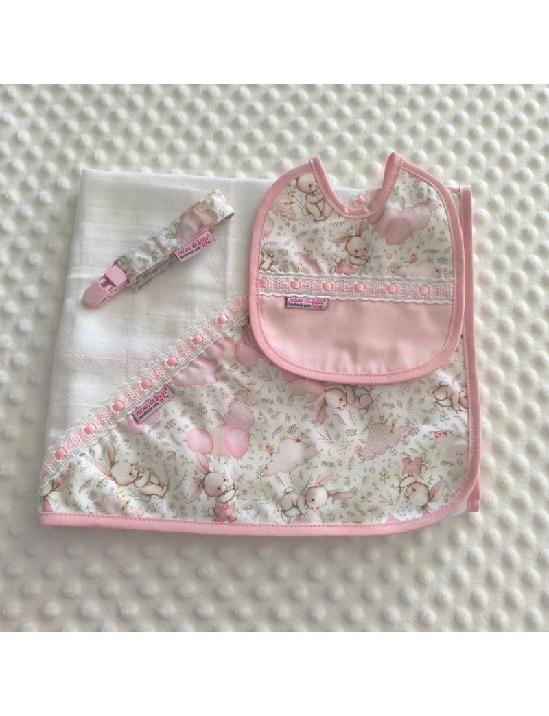 Conjunto de beb&eacute; composto por fralda branca com tri&acirc;ngulo de tecido com padr&atilde;o de coelhos e bal&otilde;es em tons de cor de rosa. Babete com padr&atilde;o igual &agrave; fralda conjugado com tecido rosa liso e com bordado ingl&ecirc;s com fita de cetim rosa. Fita para a chucha com 