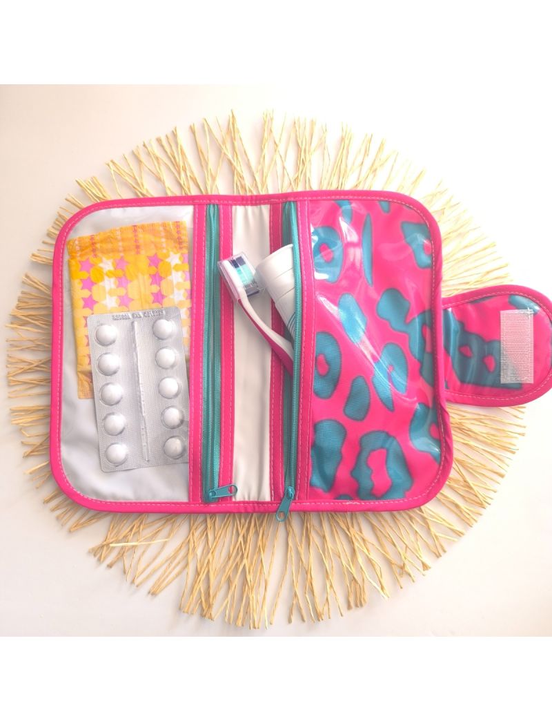 Bolsa de higiene plastificada com padr&atilde;o animal print verde &aacute;gua escuro e fundo rosa f&uacute;csia, aberta, com compartimentos para higiene oral, medica&ccedil;&atilde;o e produtos femininos. 