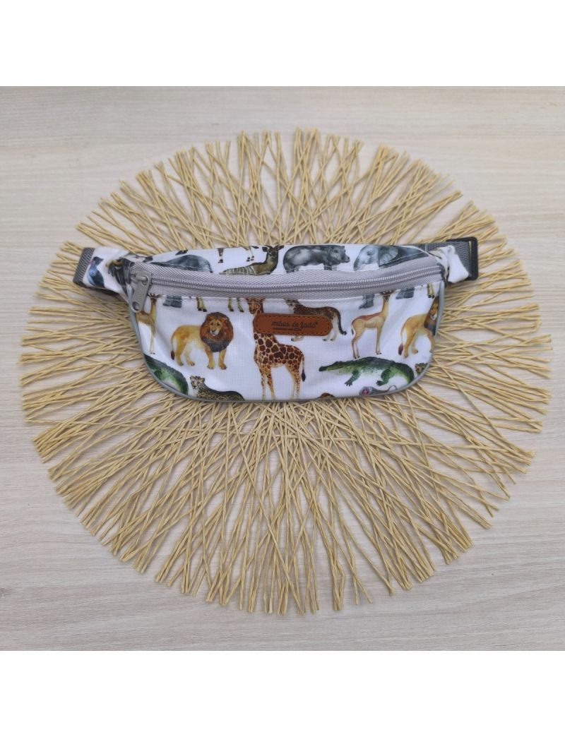 Bolsa de cintura com animais, tais como: leão, girafa, corcodilo e gazela. Alça e fecho em cinzento 