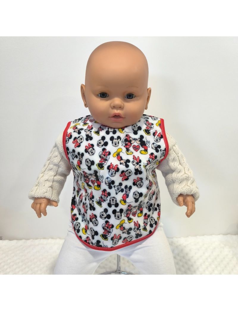Babete de beb&eacute; plastificado com padr&atilde;o repetido das personagens Minnie e Mickey Mouse com pequenos cora&ccedil;&otilde;es, debruado a vermelho.