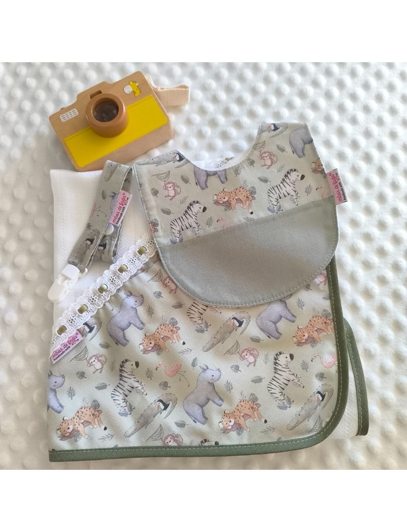 Conjunto para beb&eacute; com fundo verde seco e ilustra&ccedil;&otilde;es de animais da selva como zebras e leopardos. Inclui babete com detalhe em tecido liso, fralda de pano branca com apontamento do mesmo padr&atilde;o e bordado ingl&ecirc;s com fita de cetim verde e fita de chucha co